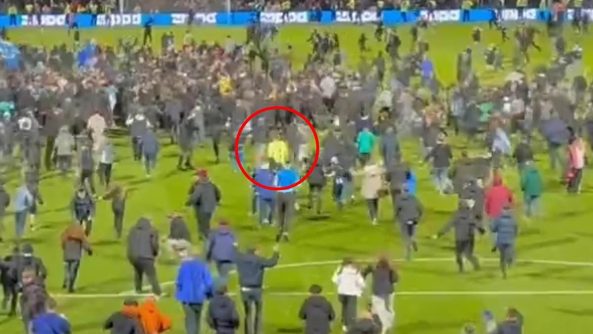 EFL goalkeeper TACKLED to the ground by fan during pitch invasion after Stockport's play-off semi-final win