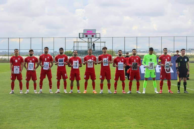 Iran players in Turkey pose with photos of young war victims
